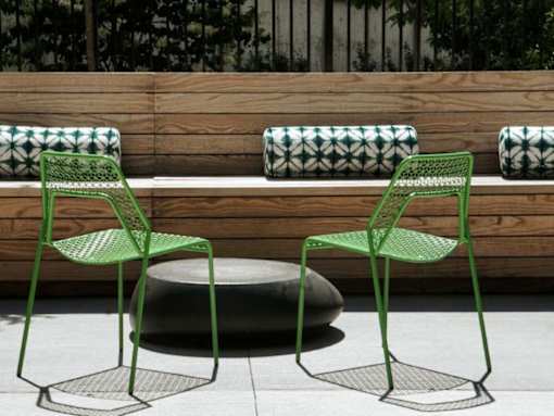 Two green chairs are placed in front of a wooden bench.at Viridium Apartments, Minneapolis 
