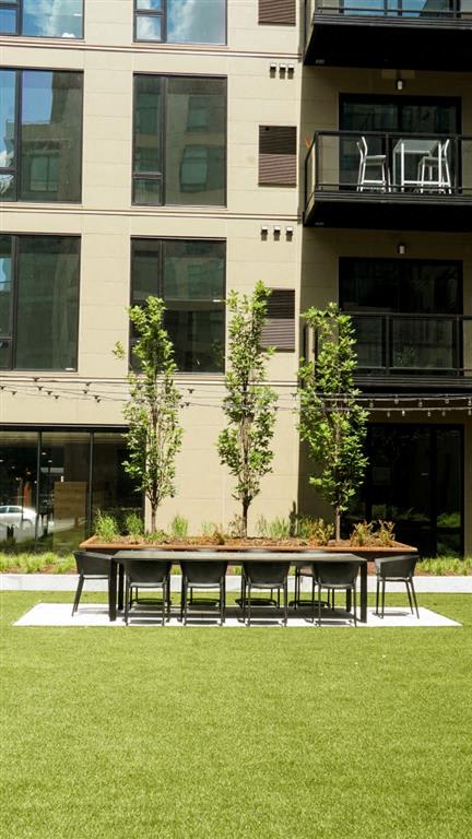 A table and chairs are set up on a lawn in front of a building.at Viridium Apartments, Minneapolis, MN 