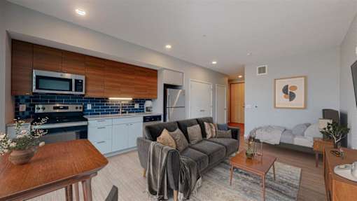 A modern living room with a grey couch and a wooden coffee table.at Viridium Apartments, Minneapolis, MN 55401 