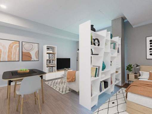 A modern bedroom with a bed, a desk, and a bookshelf.at Viridium Apartments, Minneapolis, MN 55401 