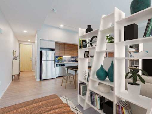 A modern kitchen with a refrigerator, a dining table, and a bookshelf.at Viridium Apartments, Minneapolis, MN 
