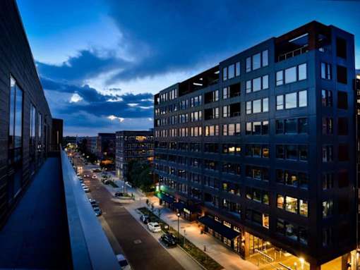 A train station with a train on the tracks and a building in the background.at Viridium Apartments, Minneapolis, MN 