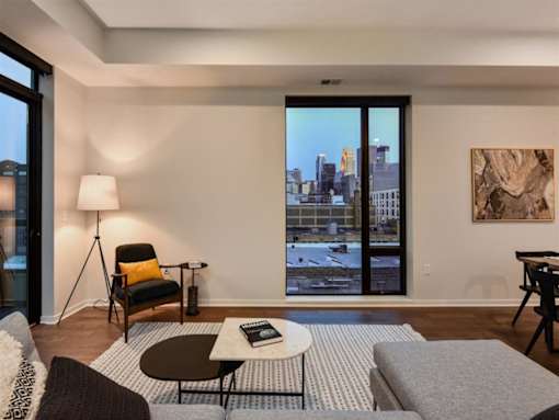 A living room with a view of the city through the windows.at Viridium Apartments, Minneapolis, MN 55401 