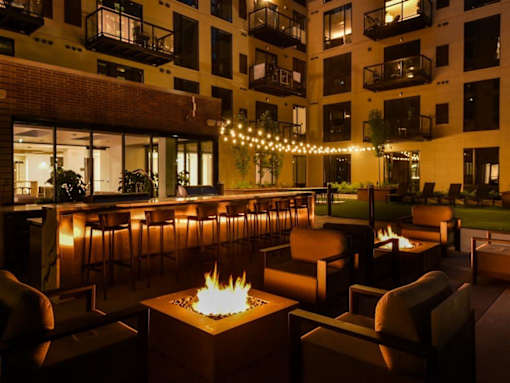 A patio with a fire pit and chairs.at Viridium Apartments, Minnesota 