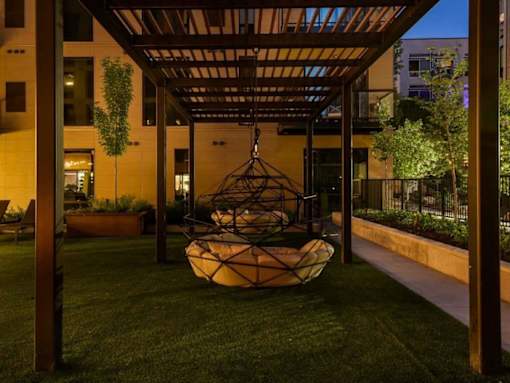 A modern outdoor seating area with a hanging chair.at Viridium Apartments, Minneapolis, MN 