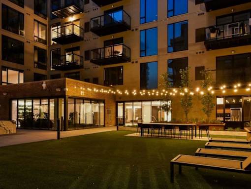 A building with a lawn and lights in front.at Viridium Apartments, Minneapolis 