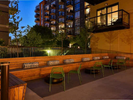 A patio with green chairs and a wooden bench.at Viridium Apartments, Minneapolis, 55401 