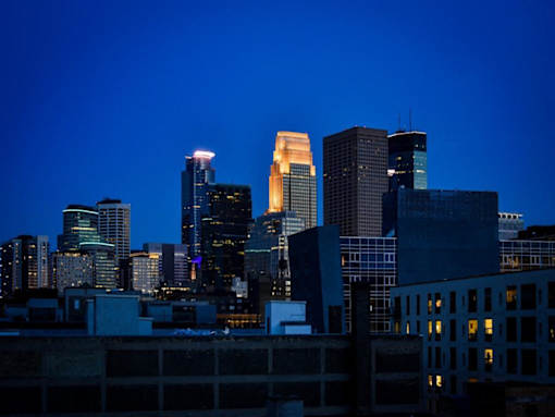A city skyline at dusk with buildings illuminated against a darkening sky.at Viridium Apartments, Minnesota, 55401