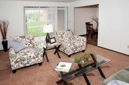 A living room with a sofa, armchair, and coffee table.