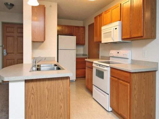 Kitchen with Wooden Cabinets at Joseph's Pointe at Upper Landing Apartments, St. Paul, 55102