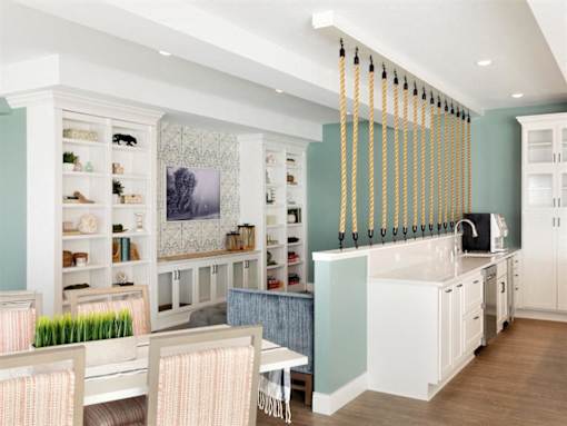 A kitchen with a white table and chairs and a blue wall.