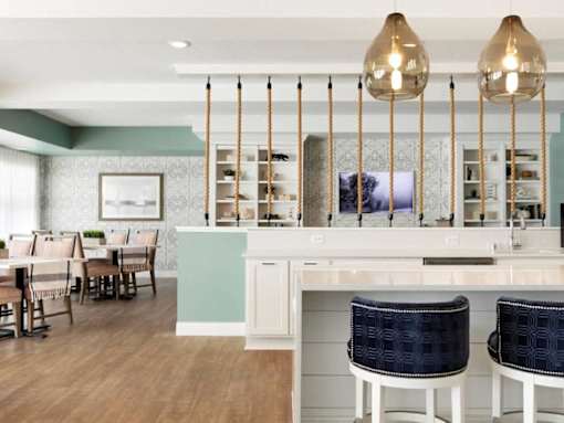 A kitchen with a white counter and blue chairs at The Barnum Apartments, Minnesota