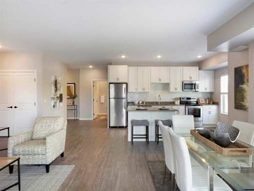 A modern kitchen with a dining table and chairs at The Barnum Apartments, MN, 55110