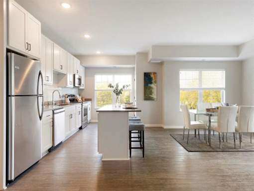 A modern kitchen with white cabinets and a large island at The Barnum Apartments, White Bear Lake, MN,  55110