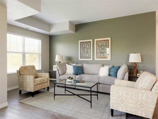 A living room with a sofa, two chairs, and a coffee table at The Barnum Apartments, White Bear Lake