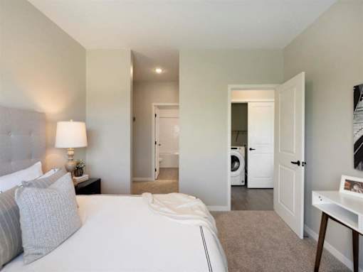 A bedroom with a large bed and a lamp on the nightstand at The Barnum Apartments, White Bear Lake, 55110