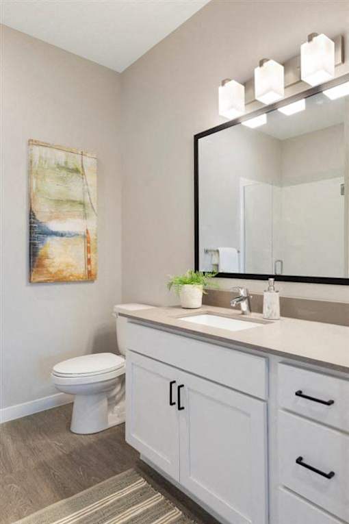 A bathroom with a toilet, sink, and a mirror at The Barnum Apartments, Minnesota