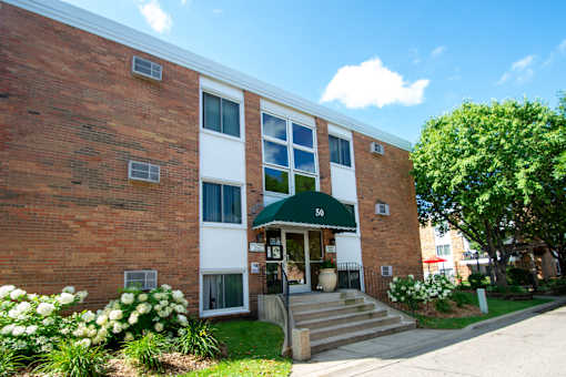 A red brick building with a green awning and the number 50 on it.