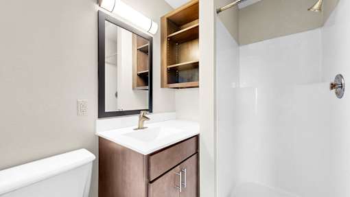 A white sink with a gold faucet and a mirror above it.
