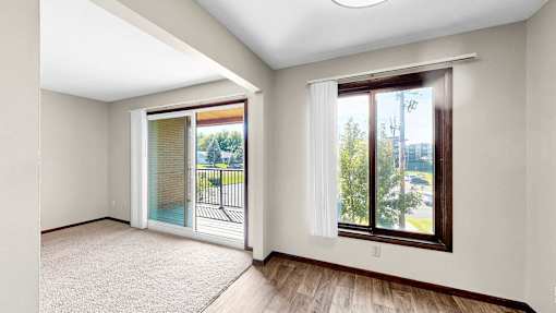 A room with a sliding glass door leading to a balcony.