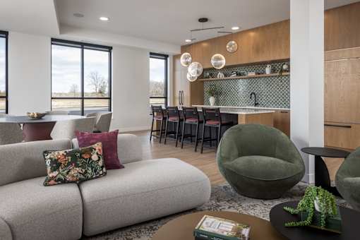 A modern living room with a grey sofa and a green armchair.