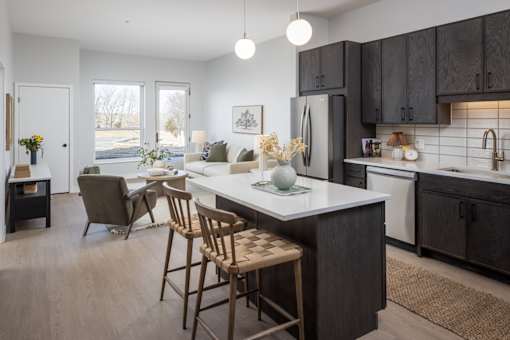 A kitchen with a table and chairs in front of a refrigerator.