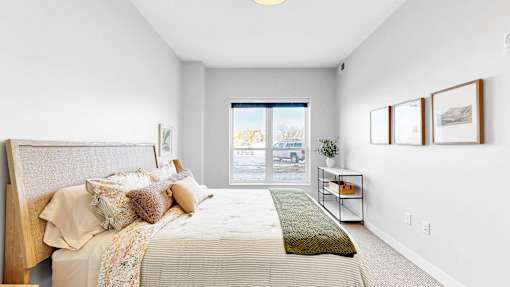 A bedroom with a large bed and a window overlooking a parking lot.