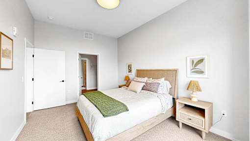 A bedroom with a bed, nightstand, and lamp.