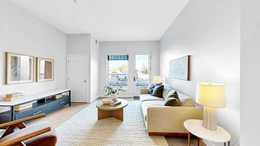 A living room with a couch, a coffee table, and a lamp.