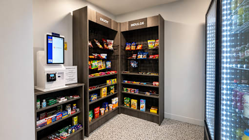 A modern vending machine is located in a room with a black and white checkered floor.