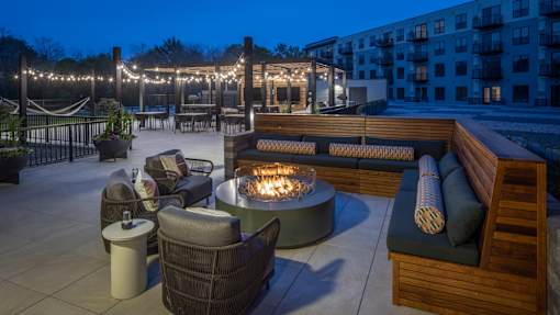 A patio with a fire pit and seating area.