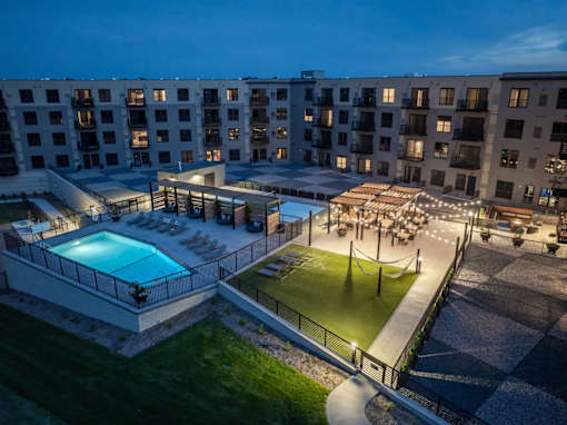 A large building with a pool and a lawn area.