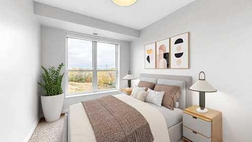 A bedroom with a large bed, a potted plant, and a lamp.