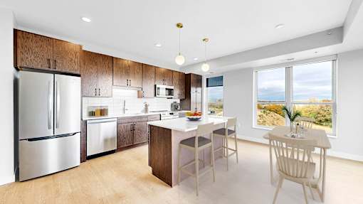 A modern kitchen with a dining table and chairs.