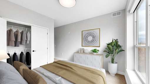 A bedroom with a bed, a plant, and a wardrobe.