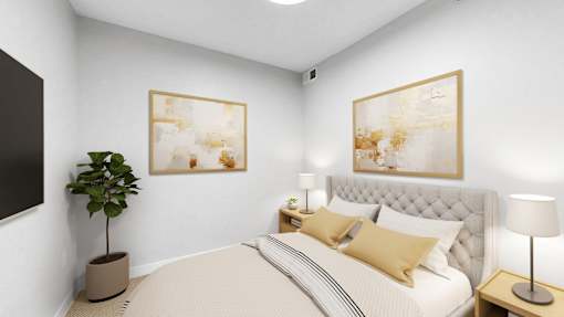 A bedroom with a large bed, a potted plant, and two framed artworks on the wall.