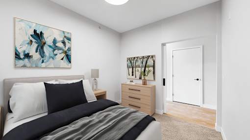 A bedroom with a bed, nightstand, and a painting on the wall.