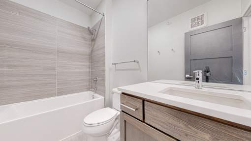 A white toilet sits next to a white sink in a modern bathroom.