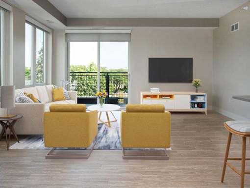 A living room with a white couch, yellow chairs, and a flat screen TV.