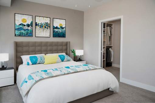 A bedroom with a large bed and two paintings on the wall.