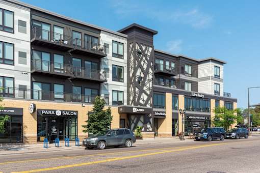 A street view of a building with a car parked in front.