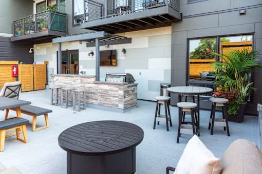 A patio area with a table, chairs, and a fireplace.
