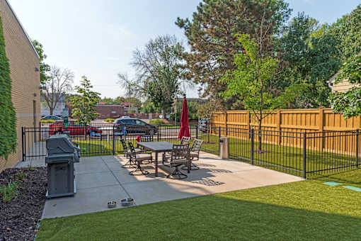 A black fence surrounds a picnic table in a park.