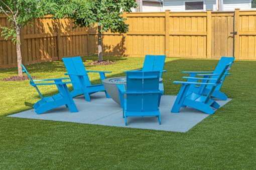 A set of blue lawn furniture is arranged on a green lawn.