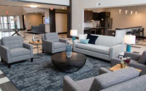 A living room with grey couches and chairs.