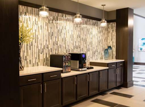 A modern kitchen with dark brown cabinets and a white countertop.