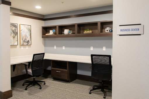 A business center with two chairs and a desk.
