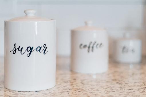 Three canisters, two of which are labeled sugar and coffee.