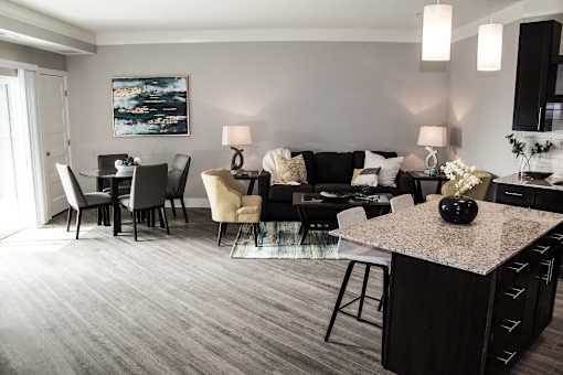 A modern living room with a grey carpet and a black and white sofa.