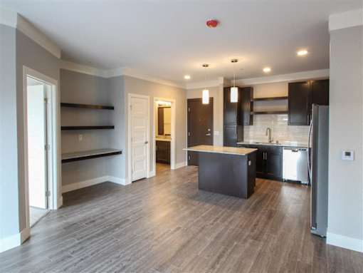A kitchen with a refrigerator, sink, and cabinets.